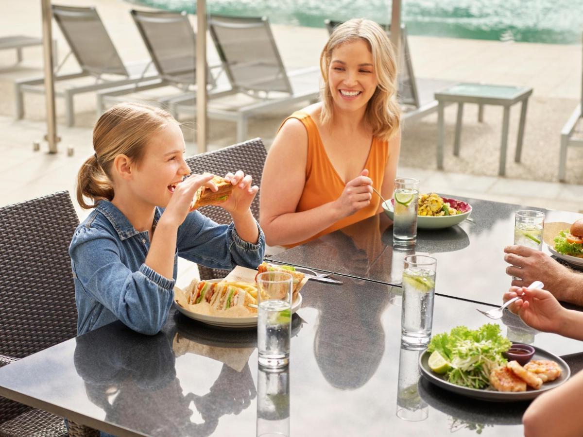 Racv Royal Pines Resort Gold Coast Benowa Eksteriør billede A family dining at the poolside